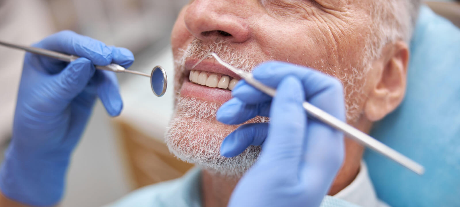 Eldelry Man Smiling During A Dental Appointment